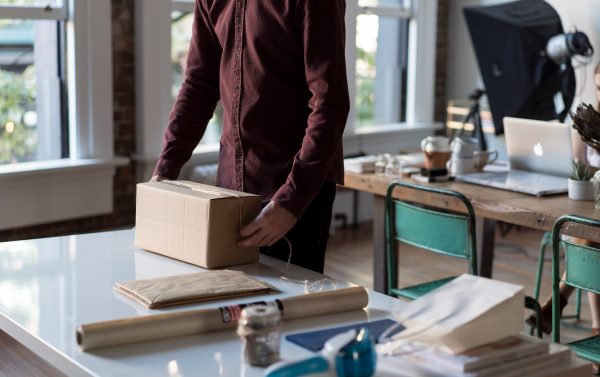 Image Of A Man In An Office Room Holding A Box